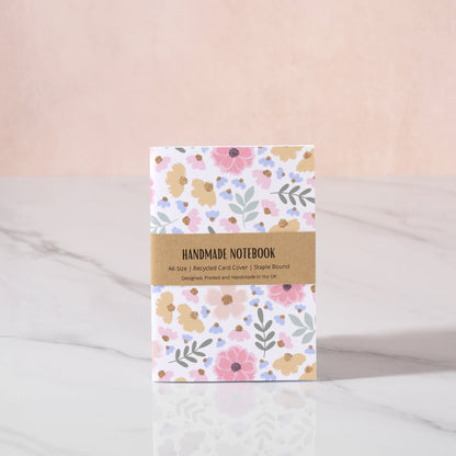 Handmade notebook with floral design on a light pink background