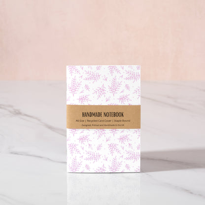 Handmade notebook with pink floral design on a white background