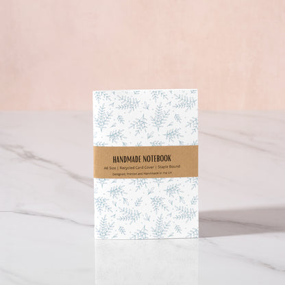 Handmade notebook with green floral design on a white background