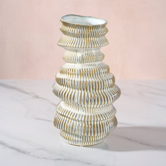 Decorative vase with ribbed design on a light pink background
