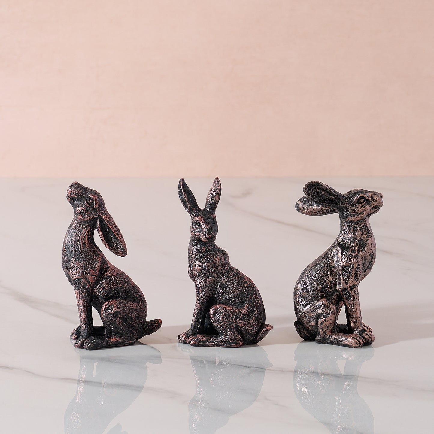 Three hare ornaments in different poses.