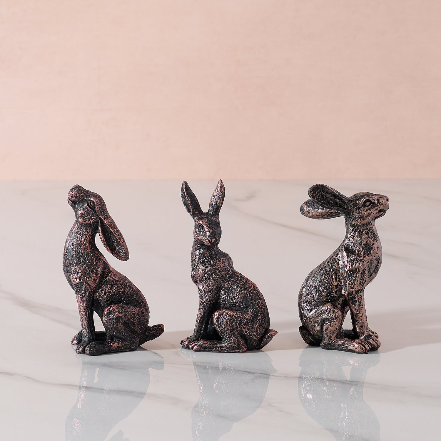 Three hare ornaments in different poses.