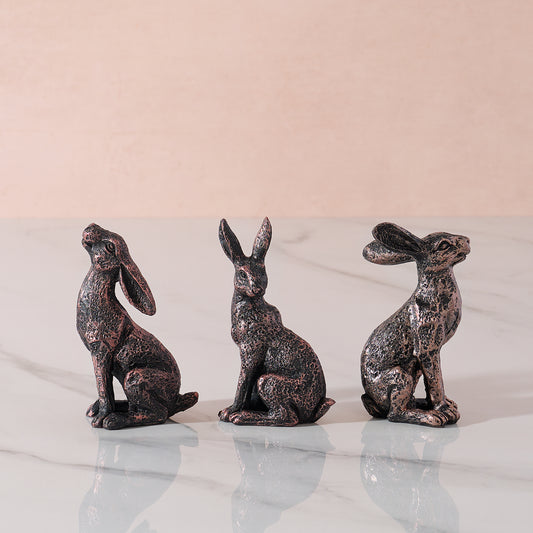 Three hare ornaments in different poses.