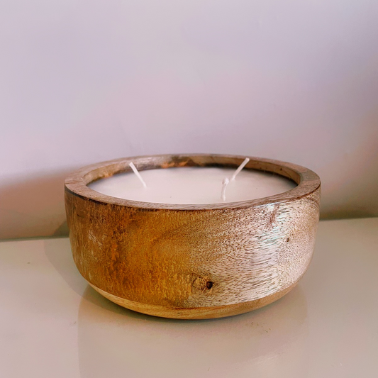 Large mango wood candle photographed with warm lighting