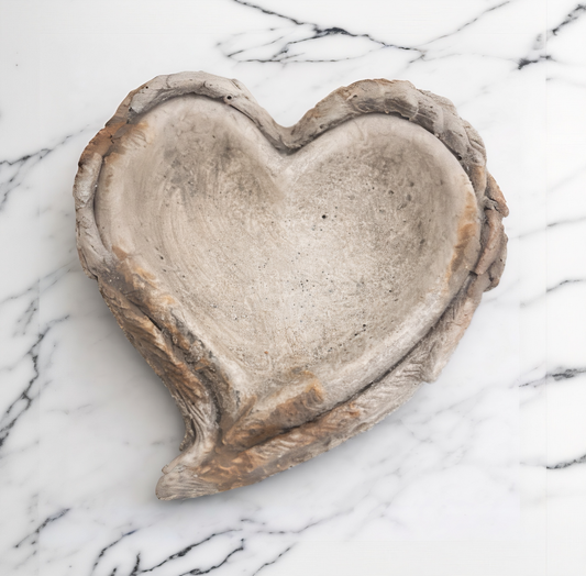 Heart-shaped stone dish on a marble surface